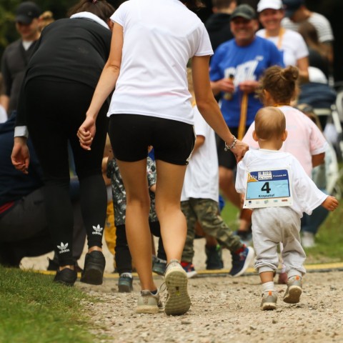 Powiększ obraz: mama i synek biegnący w wyścigu, widok z tyłu