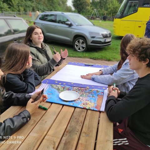 Powiększ obraz: uczniowie przy stole na dworze